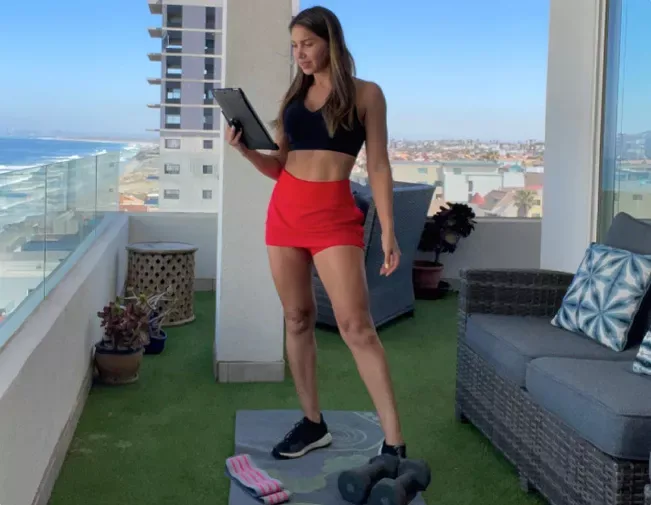 Lucero Galiano entrenando en una terraza con mancuernas y tapete
